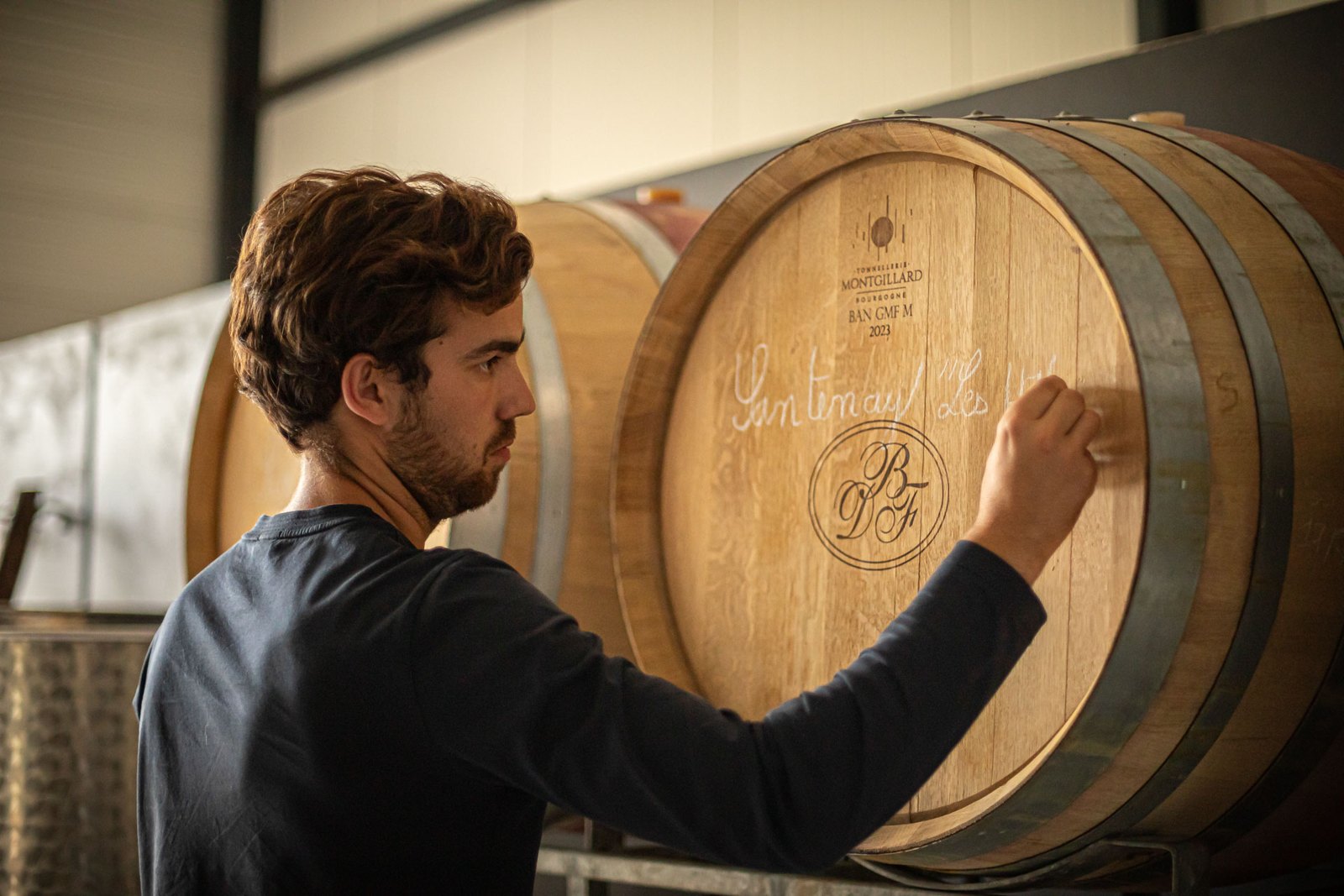 Vigneron marquant un fût à la craie — reportage Naos